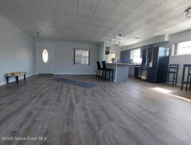 interior space featuring plenty of natural light, baseboards, and wood finished floors