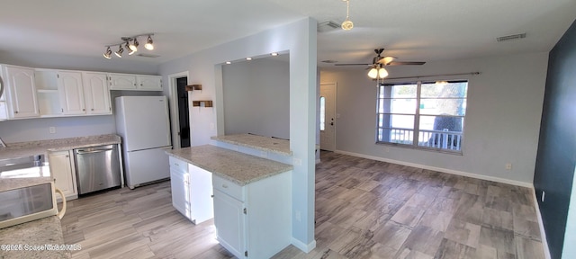 kitchen featuring visible vents, a ceiling fan, freestanding refrigerator, white cabinetry, and stainless steel dishwasher