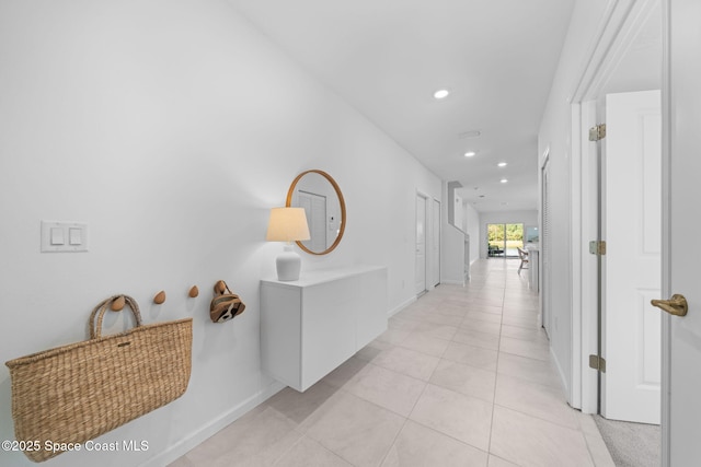 hallway featuring recessed lighting, baseboards, and light tile patterned floors