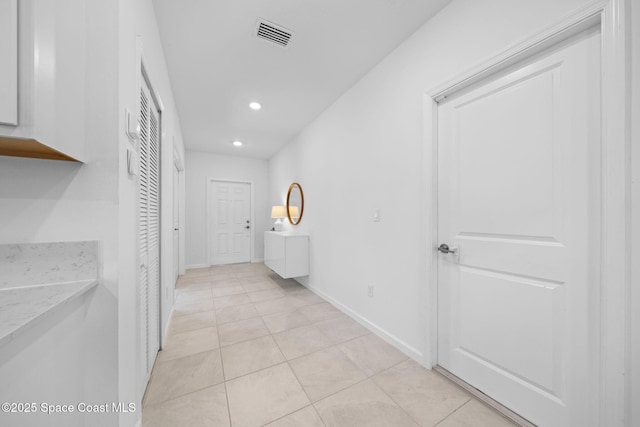 hall featuring light tile patterned floors, baseboards, visible vents, and recessed lighting