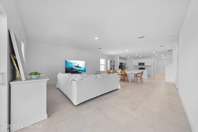 living room with light tile patterned flooring, baseboards, visible vents, and recessed lighting