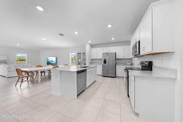 kitchen featuring visible vents, open floor plan, light countertops, stainless steel appliances, and a sink