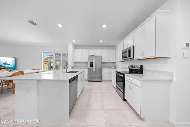 kitchen featuring appliances with stainless steel finishes, white cabinetry, a sink, and visible vents