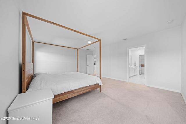 bedroom featuring ensuite bath, carpet flooring, and baseboards