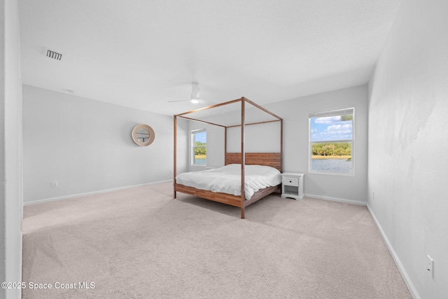 unfurnished bedroom with carpet floors, multiple windows, visible vents, and baseboards