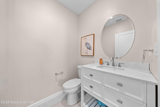 half bath featuring toilet, tile patterned flooring, vanity, and baseboards