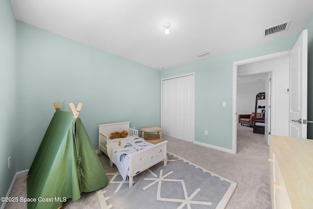 carpeted bedroom with a closet, visible vents, and baseboards