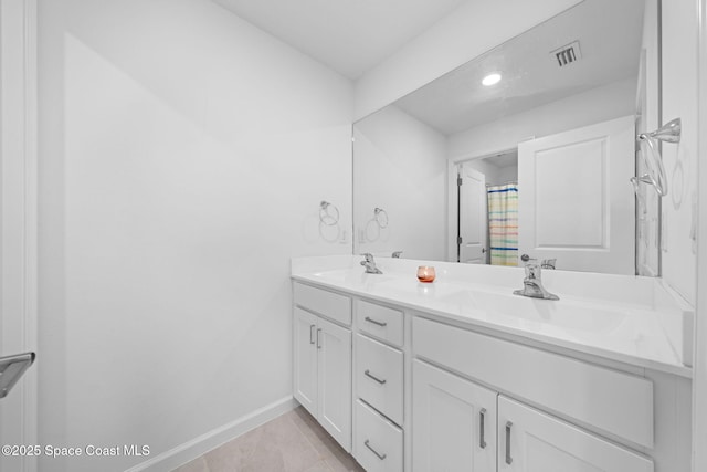 full bath featuring visible vents, a sink, baseboards, and double vanity