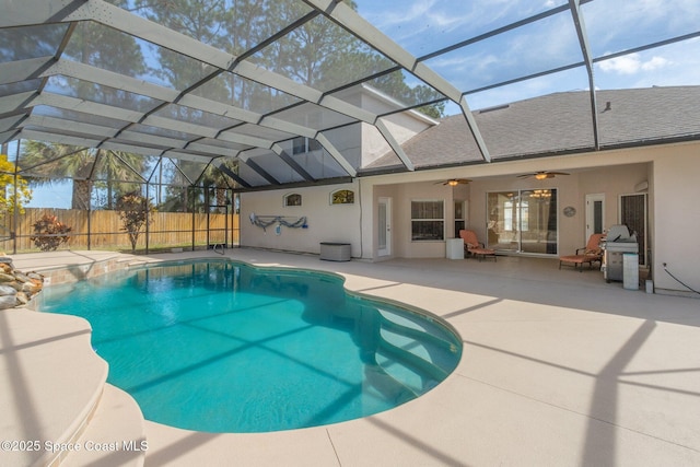 view of pool with ceiling fan, a patio, glass enclosure, fence, and a fenced in pool