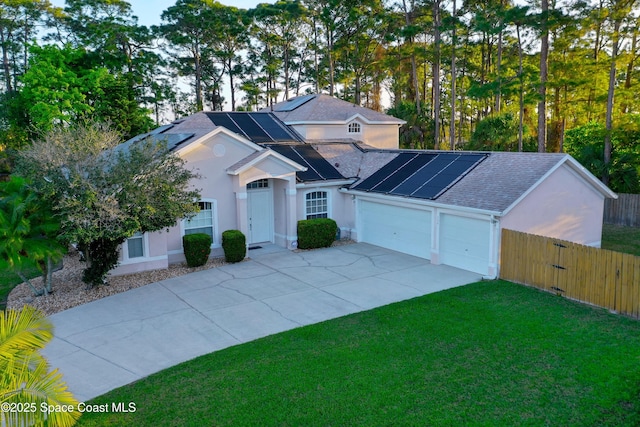 view of front of property with stucco siding, a front yard, fence, a garage, and driveway