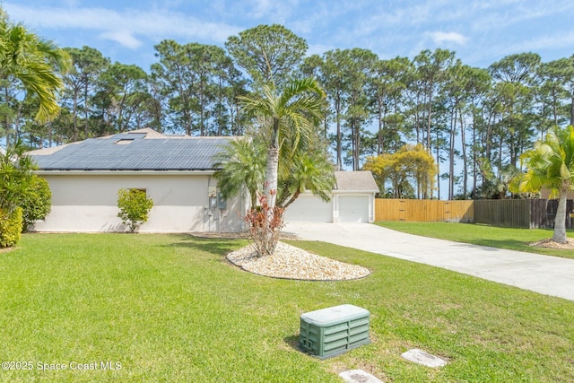 exterior space with a garage, fence, a lawn, and stucco siding