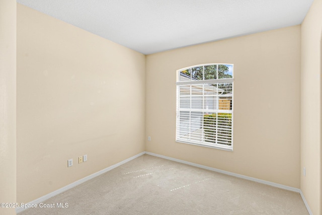 spare room with carpet and baseboards