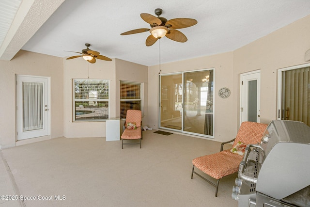 living area with carpet floors and ceiling fan