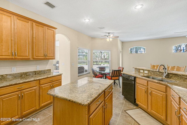 kitchen featuring a wealth of natural light, visible vents, a ceiling fan, dishwasher, and a sink