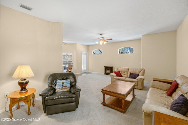 living room with carpet floors, baseboards, visible vents, and ceiling fan