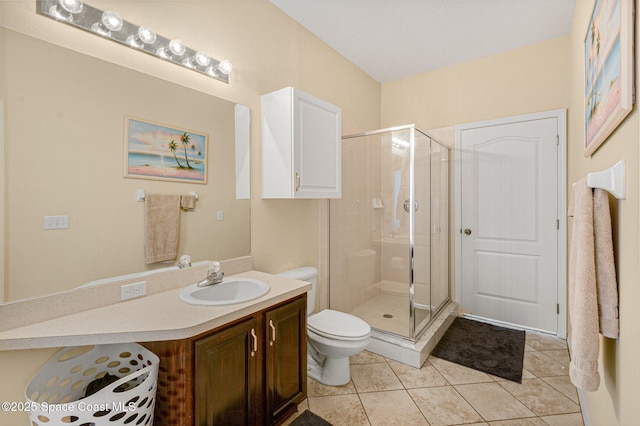 full bath featuring a stall shower, tile patterned flooring, vanity, and toilet