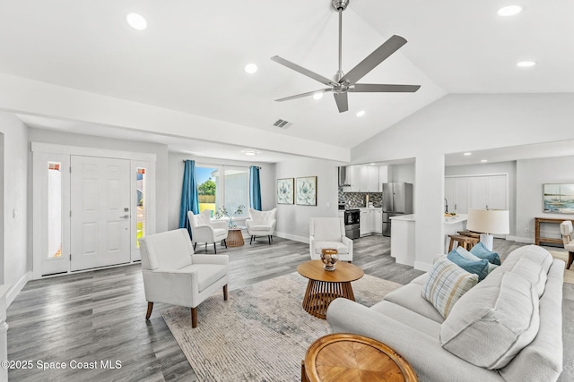 living area featuring baseboards, light wood-style flooring, visible vents, and recessed lighting