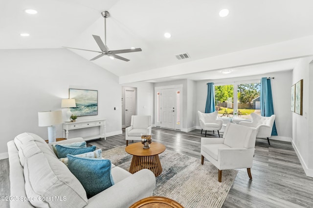 living area with vaulted ceiling, wood finished floors, visible vents, and baseboards