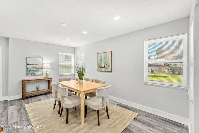 dining room featuring baseboards, wood finished floors, and recessed lighting