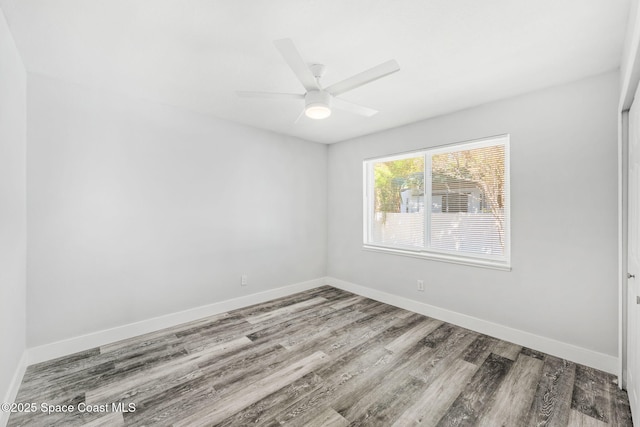 empty room featuring ceiling fan, wood finished floors, and baseboards