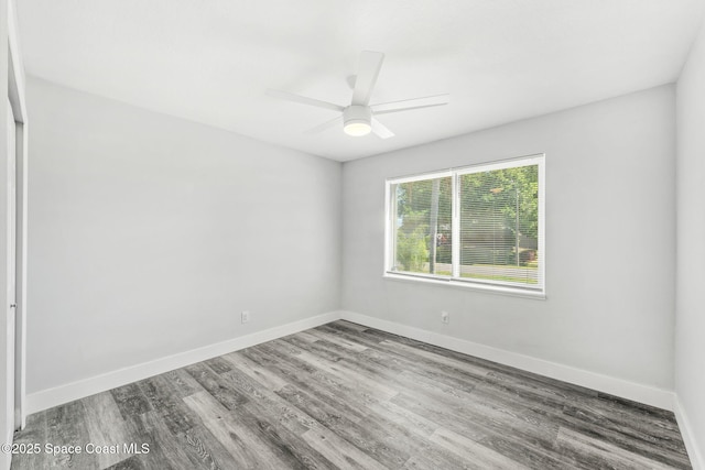 empty room featuring ceiling fan, baseboards, and wood finished floors