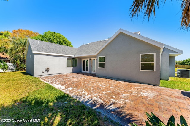 rear view of house featuring central air condition unit, a patio area, stucco siding, and a yard