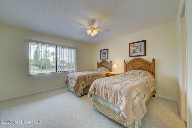 carpeted bedroom featuring ceiling fan, baseboards, and a textured ceiling