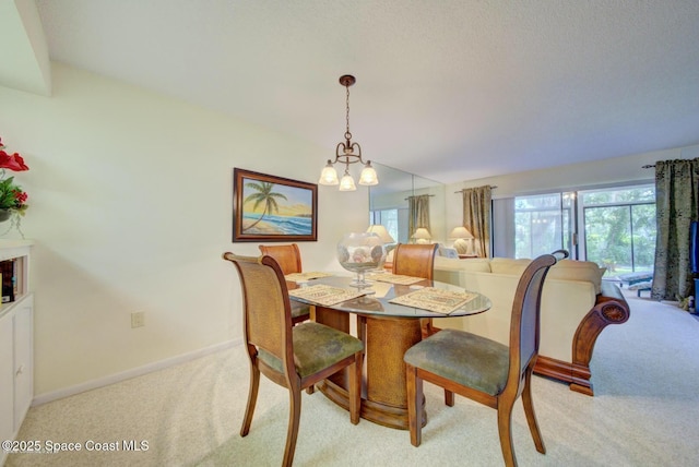 dining room featuring a wealth of natural light, carpet, a chandelier, and baseboards