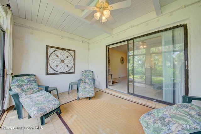 interior space featuring light tile patterned floors, ceiling fan, beamed ceiling, and wooden ceiling