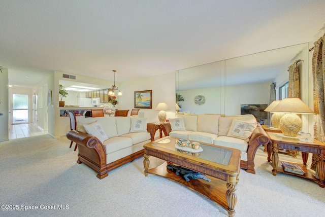 living area featuring carpet floors and visible vents