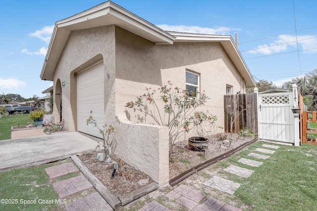 view of property exterior with a gate and stucco siding