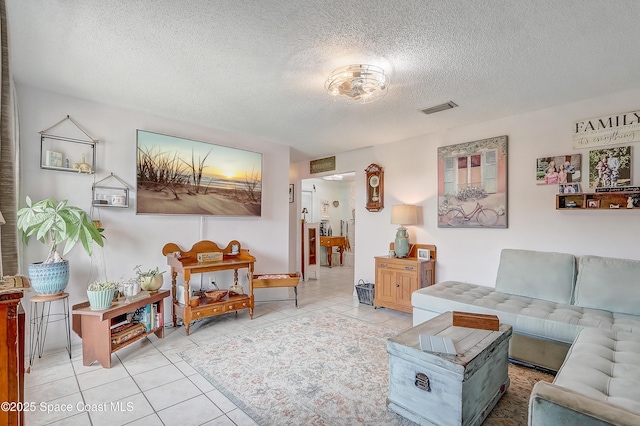 tiled living room with visible vents and a textured ceiling