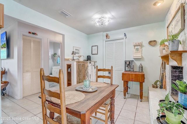 dining area with light tile patterned floors and visible vents