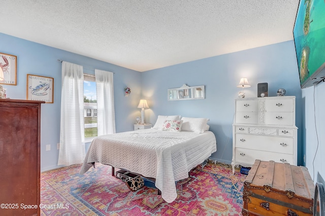 bedroom featuring a textured ceiling and baseboards