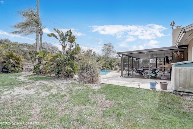 view of yard with a patio, a sunroom, and an outdoor pool