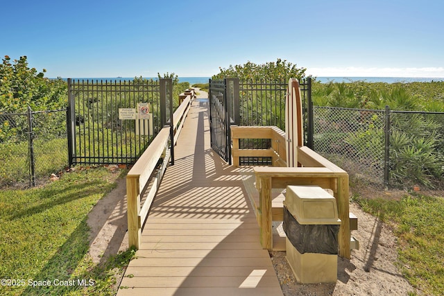 surrounding community with a water view and fence