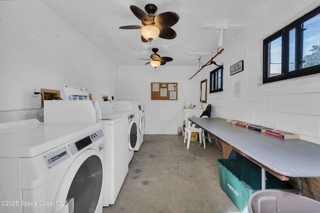 common laundry area featuring a sink, concrete block wall, a ceiling fan, and washing machine and clothes dryer