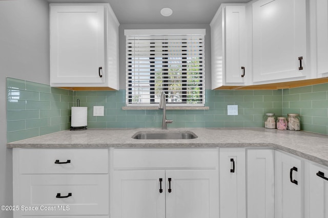 kitchen featuring a sink, decorative backsplash, and white cabinetry