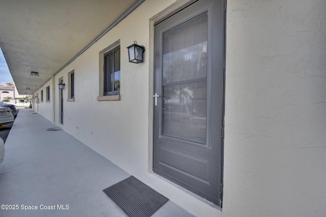 view of exterior entry with visible vents and stucco siding