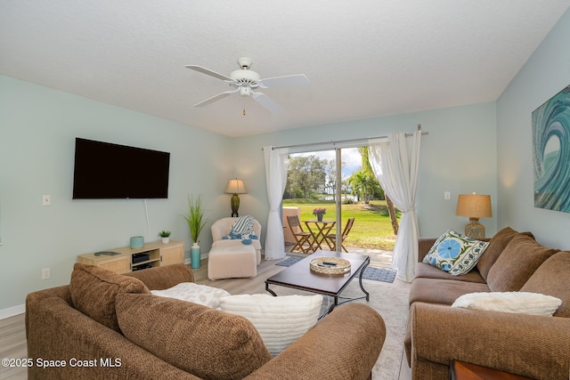 living room with ceiling fan, wood finished floors, and baseboards