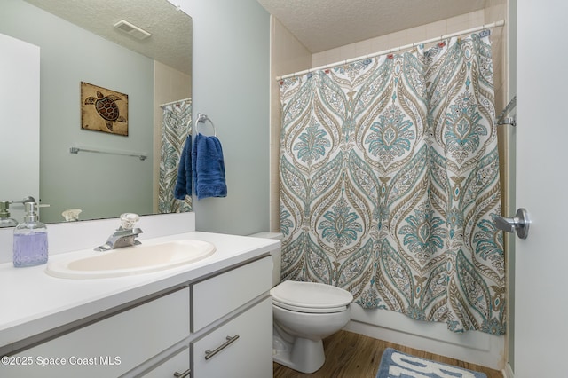 full bathroom with a textured ceiling, vanity, wood finished floors, and toilet