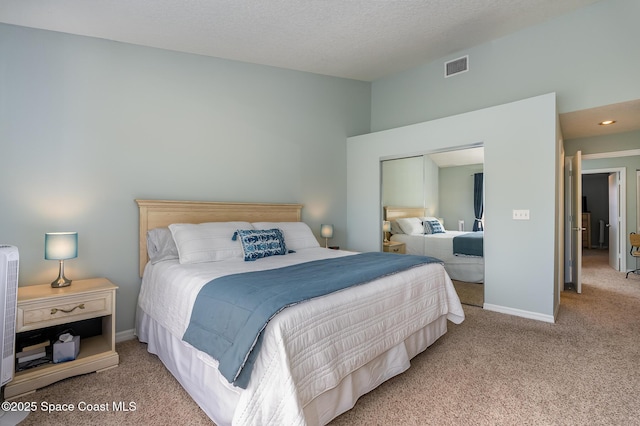 bedroom with carpet floors, visible vents, a textured ceiling, and baseboards