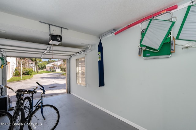 garage with a garage door opener and baseboards