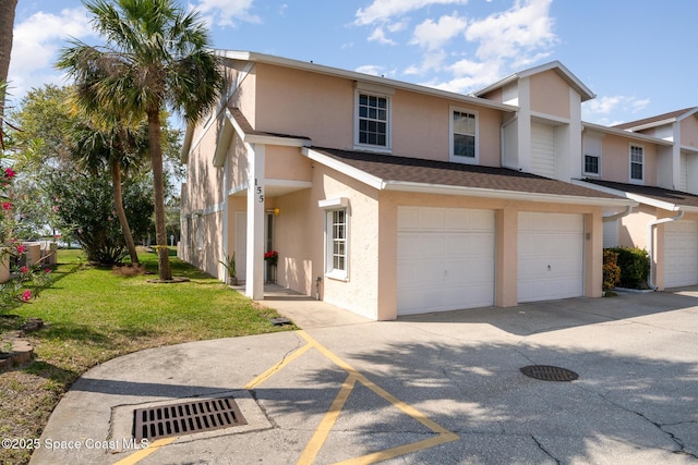 multi unit property featuring a garage, roof with shingles, a front lawn, and stucco siding