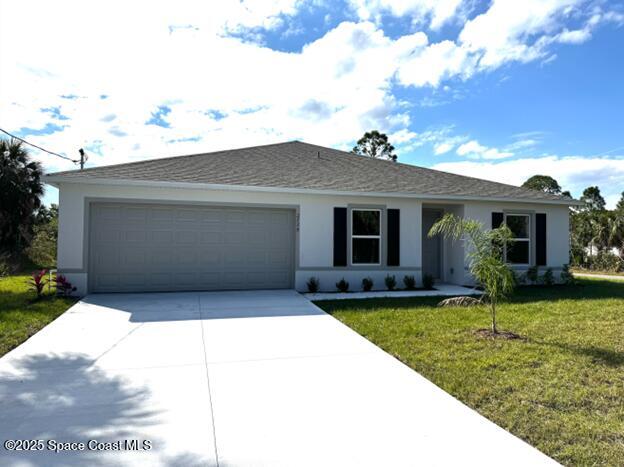 single story home featuring a garage, a front lawn, driveway, and stucco siding