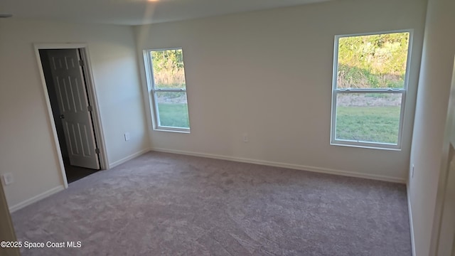 empty room featuring baseboards and carpet floors