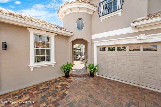 entrance to property with stucco siding and a tile roof