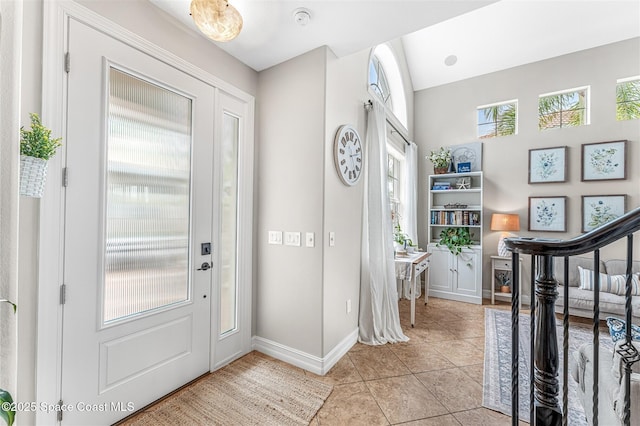 entrance foyer with light tile patterned flooring and baseboards