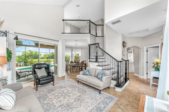 living area with visible vents, a wealth of natural light, stairway, and arched walkways