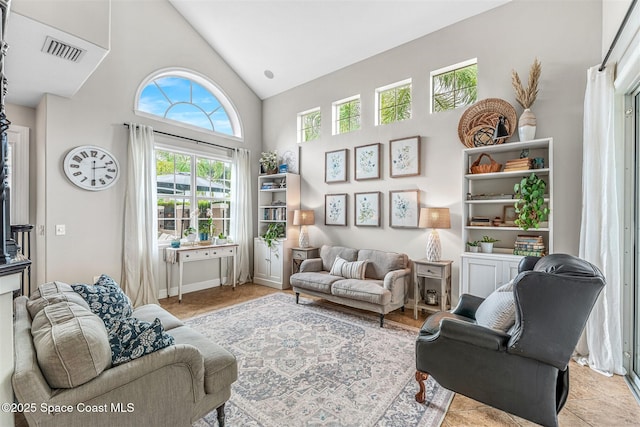 living room with high vaulted ceiling and visible vents